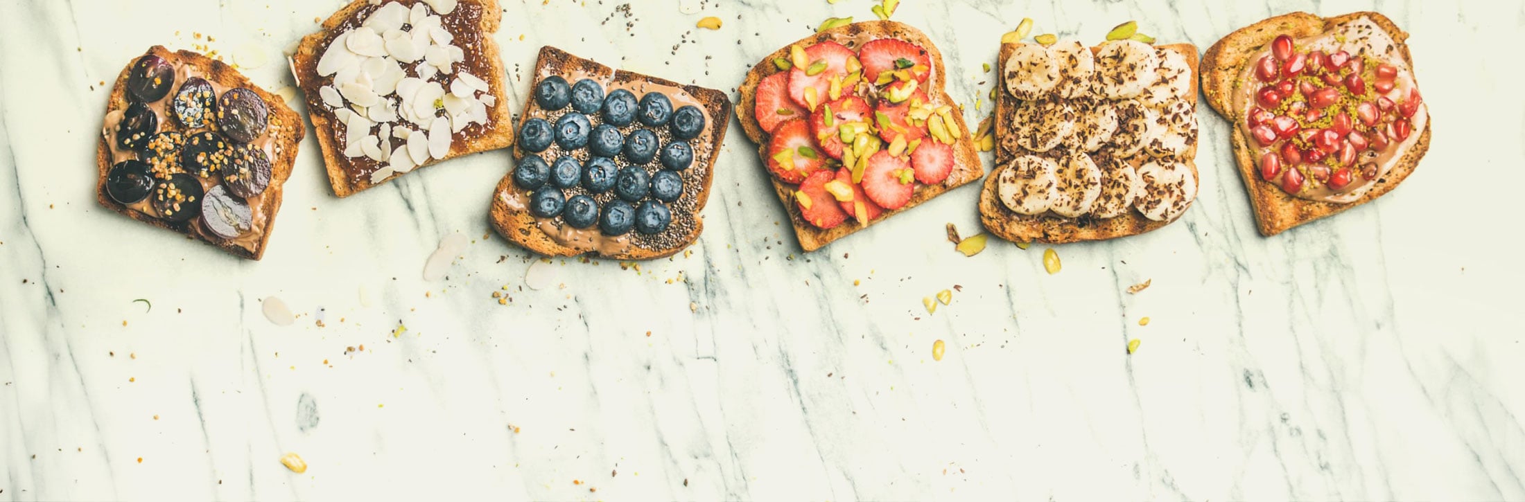Assorted topped toasts on a marble surface